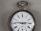 une montre de poche en argent avec des chiffres romains