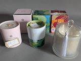 a cup of tea next to a candle and a box of tea bags
