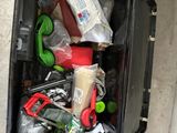 a black suitcase filled with assorted items sitting on the floor