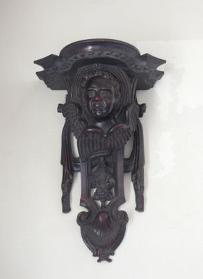 a wall clock that has a carved face on it