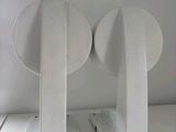 two white speakers sitting on top of a white table