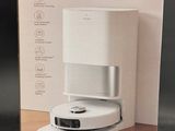 packaging of a white box containing a coffee machine on a wooden table