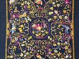 une écharpe noire ornée de fleurs et d'oiseaux jaunes et roses