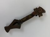 une vieille clé en bronze avec un manche en bois posée sur une surface blanche