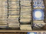 several boxes of blue and white tiles are stacked on top of each other