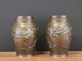 une paire de vases en bronze ornés d'oiseaux et de fleurs, posés sur une table