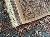an image of a blue and pink rug on a wooden floor
