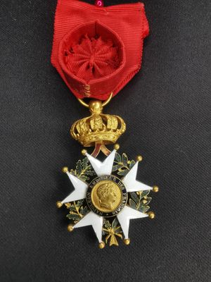 un gros plan d'une médaille entourée d'un ruban rouge
