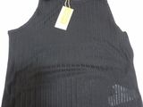 a black tank top with holes and a tag on it