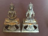 deux statues de bouddhas assis sur une table