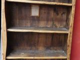 une bibliothèque en bois avec un tableau accroché au mur