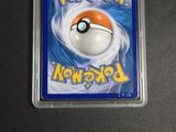 the pokemon card is in a plastic case on a table