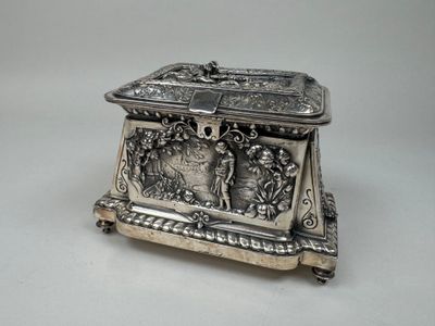 an antique silver box with a bird on it on a table