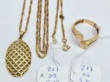trois colliers en or et une bague avec une étiquette de prix