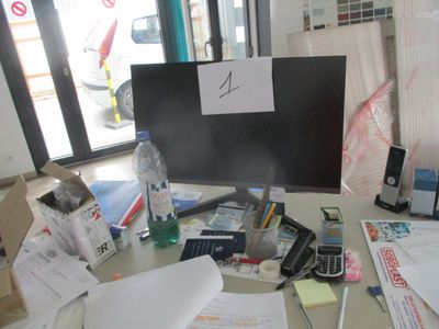 un bureau encombré, sur lequel se trouvent de nombreuses fournitures de bureau