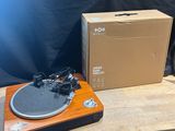 a record player sitting on a wooden table next to a box