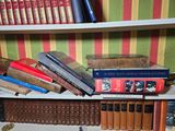 many books that are on a shelf in a room