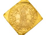 gros plan d'une pièce d'or sur une surface blanche
