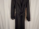 the coat is black and has a belt on the waist