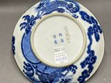 an oriental blue and white plate with a dragon design on it