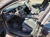 the interior of a car with the door open and the driver ' s seat down