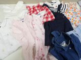 a lot of baby clothes that are laying on a bed