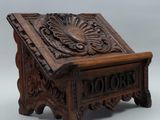 an old wooden box with a carved design on top of it