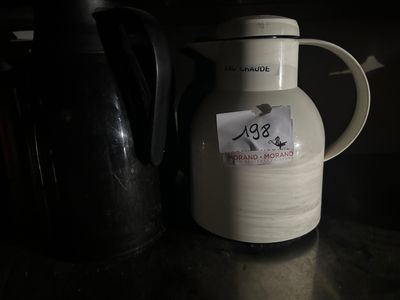 une cruche blanche avec un autocollant, posée sur un comptoir