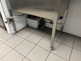 a stainless steel sink in the middle of a tiled floor