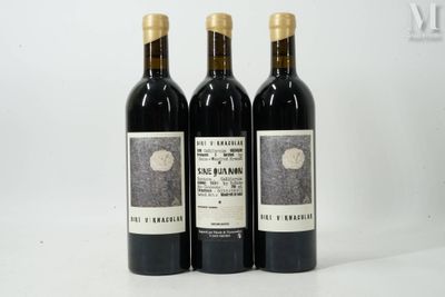 three bottles of wine sitting on top of a white table