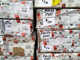 Plusieurs piles de cartons sont empilées les unes sur les autres dans un entrepôt.