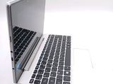 a white laptop with a black keyboard on a white surface