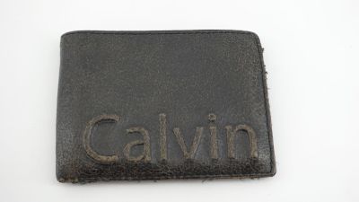 portefeuille en cuir noir sur lequel est gravé le nom « Calvin »