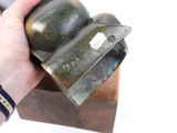 a person holding a knife in their hand over a block of wood