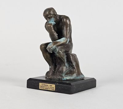 statue représentant un homme assis sur un rocher, les mains posées sur les genoux