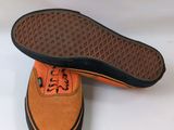 an image of a pair of orange and black shoes on a white surface