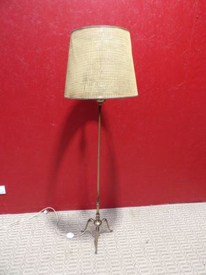 une lampe posée par terre devant un mur rouge
