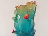 un vase en verre avec une fleur à l'intérieur sur une table