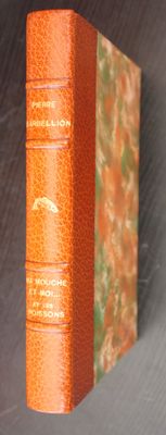 an orange book sitting on top of a table next to a white wall
