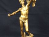 a gold statue of a woman holding a bird in her hand