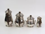three pieces of silver tea and coffee set on a white surface
