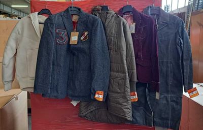 de nombreuses vestes suspendues à un portant dans un magasin