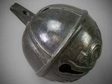 a metal bell that is on a white surface