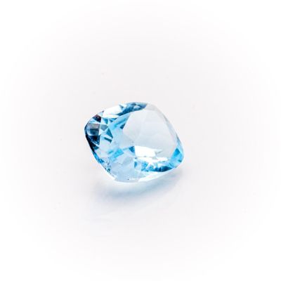 a close up of a blue diamond on a white surface