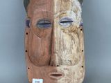 une image représentant un masque en bois aux yeux bleus et au visage brun