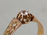 a close up of a gold ring with a diamond on top of it