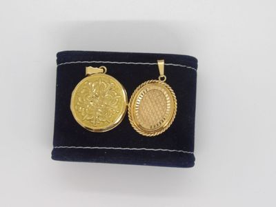 un gros plan sur une paire de boucles d'oreilles en or posées sur un tissu bleu