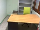 un bureau avec une chaise et une bibliothèque dans un coin