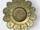 a gold plate with leaves on it on a white surface