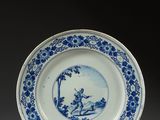 assiette bleue et blanche représentant un homme et une femme dans un bateau